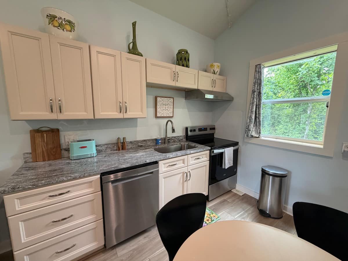 Full kitchen with stove, dishwasher, and granite counters