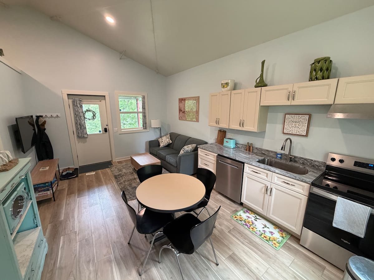 Open living room and kitchen with sofa, dining table, and TV
